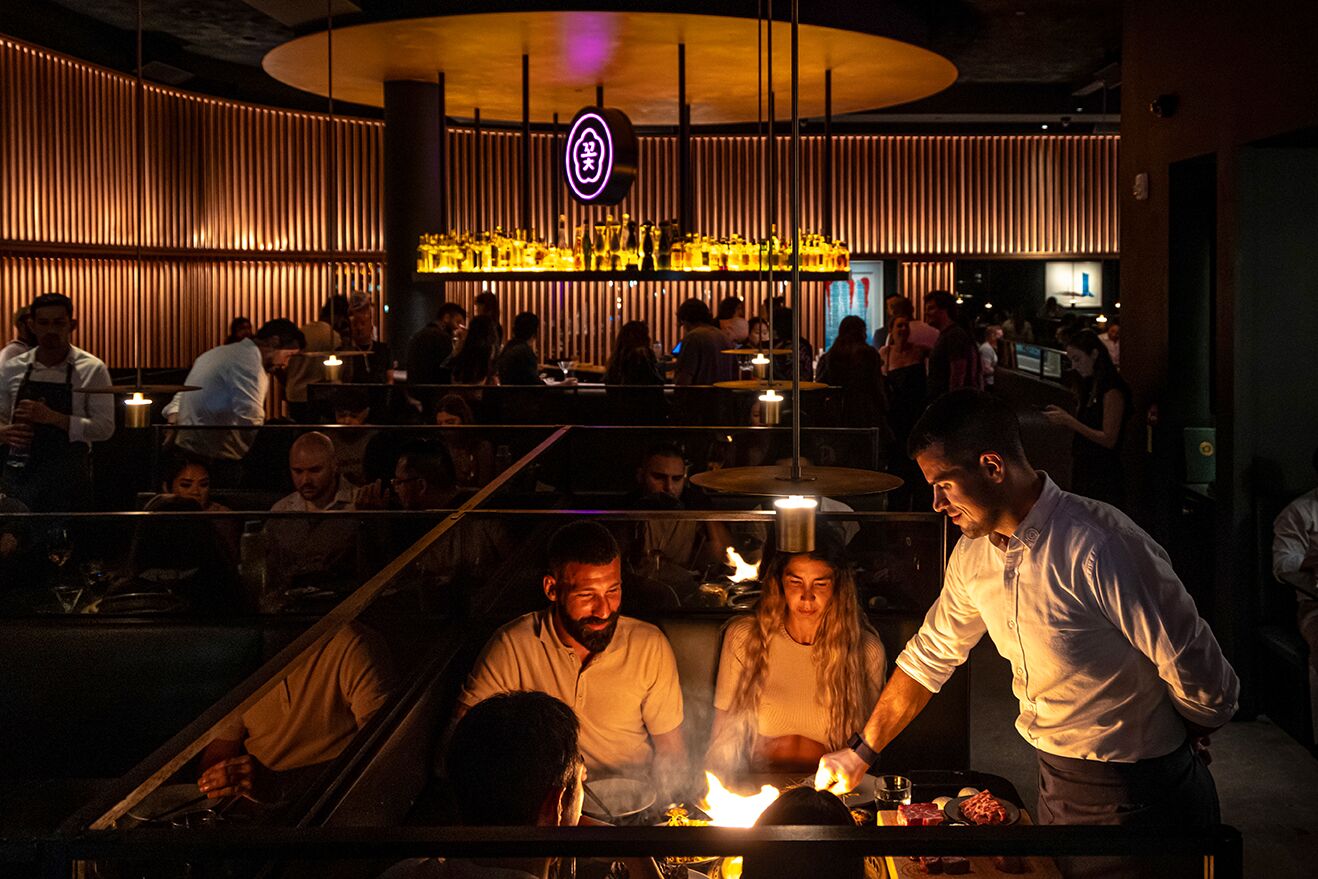 Guests at a candlelit table during dinner service